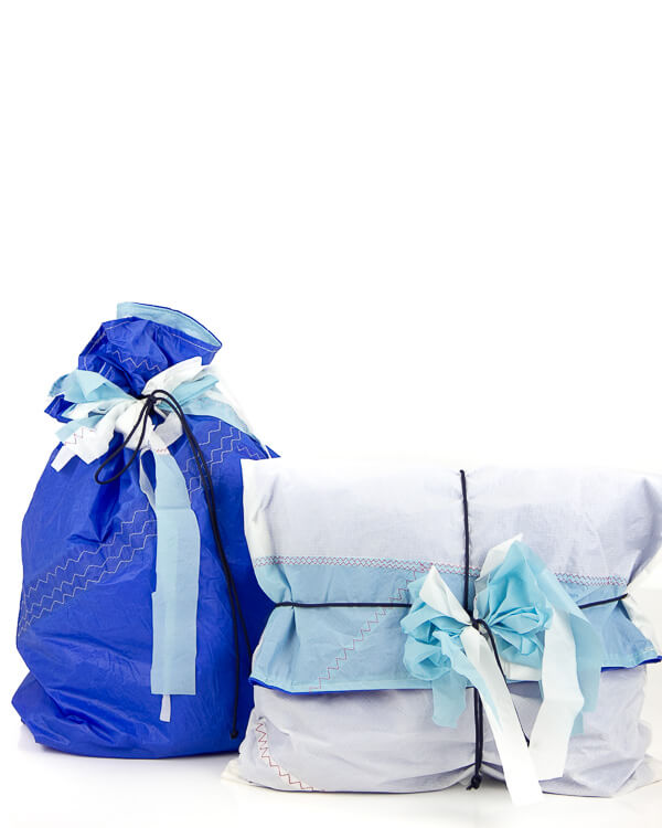 due pacchetti regalo blu e bianco appoggiati su tavolo