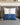 cuscino bianco e blu stile marinaro appoggiato su divano grigio