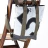 zaino in tessuto tecnico bianco appoggiato su schienale sedia in legno